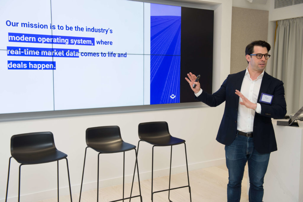 A male in jeans and a suit jacket giving a presentation