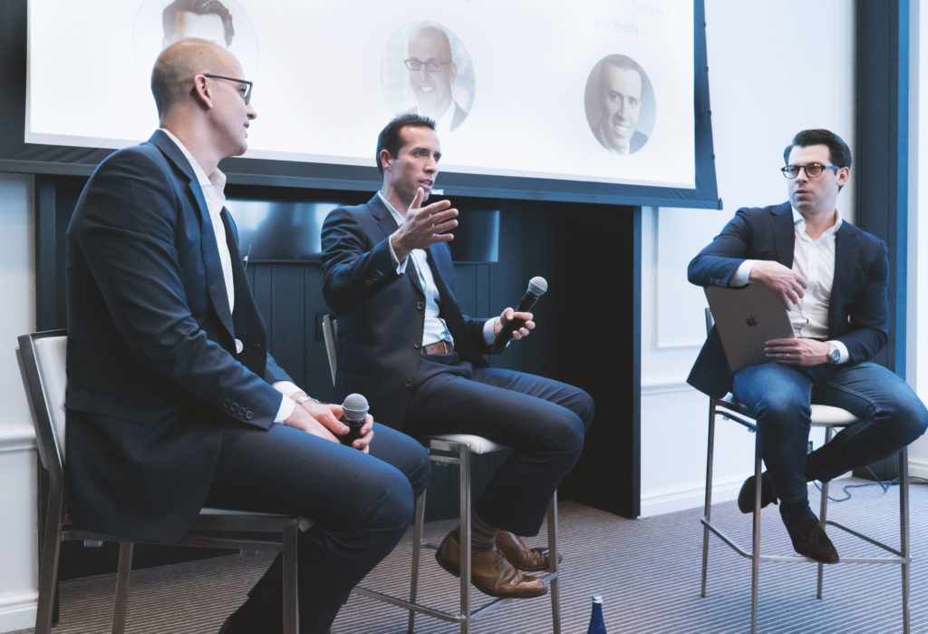 A panel of three men in suits in discussion